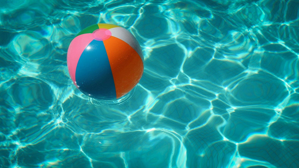 Beach ball floating in a clear turquoise blue pool